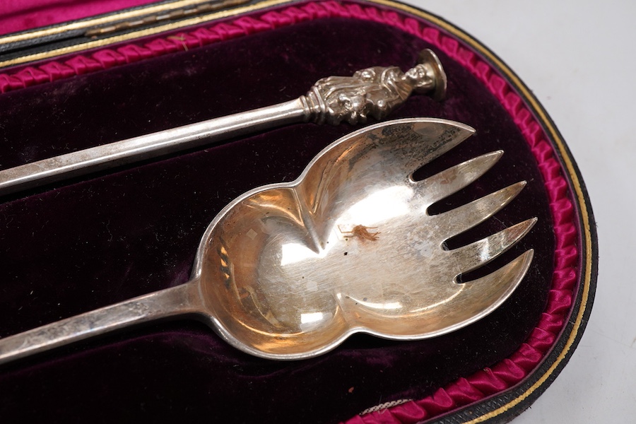 A cased pair of late Victorian silver salad servers, with apostle finials, maker's mark rubbed, London, 1896, 23.1cm, 5.8oz.